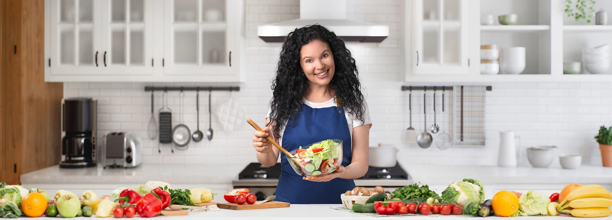 Yana in a kitchen preparing a fresh vegetable salad for Delica Recipes.