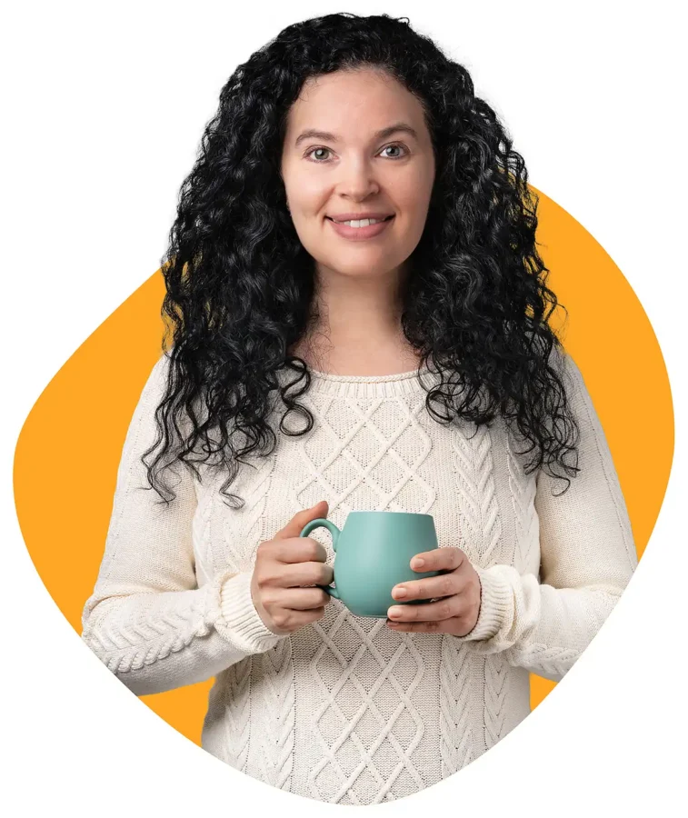 Yana, founder and recipe creator at Delica Recipes, smiling while holding a green mug.